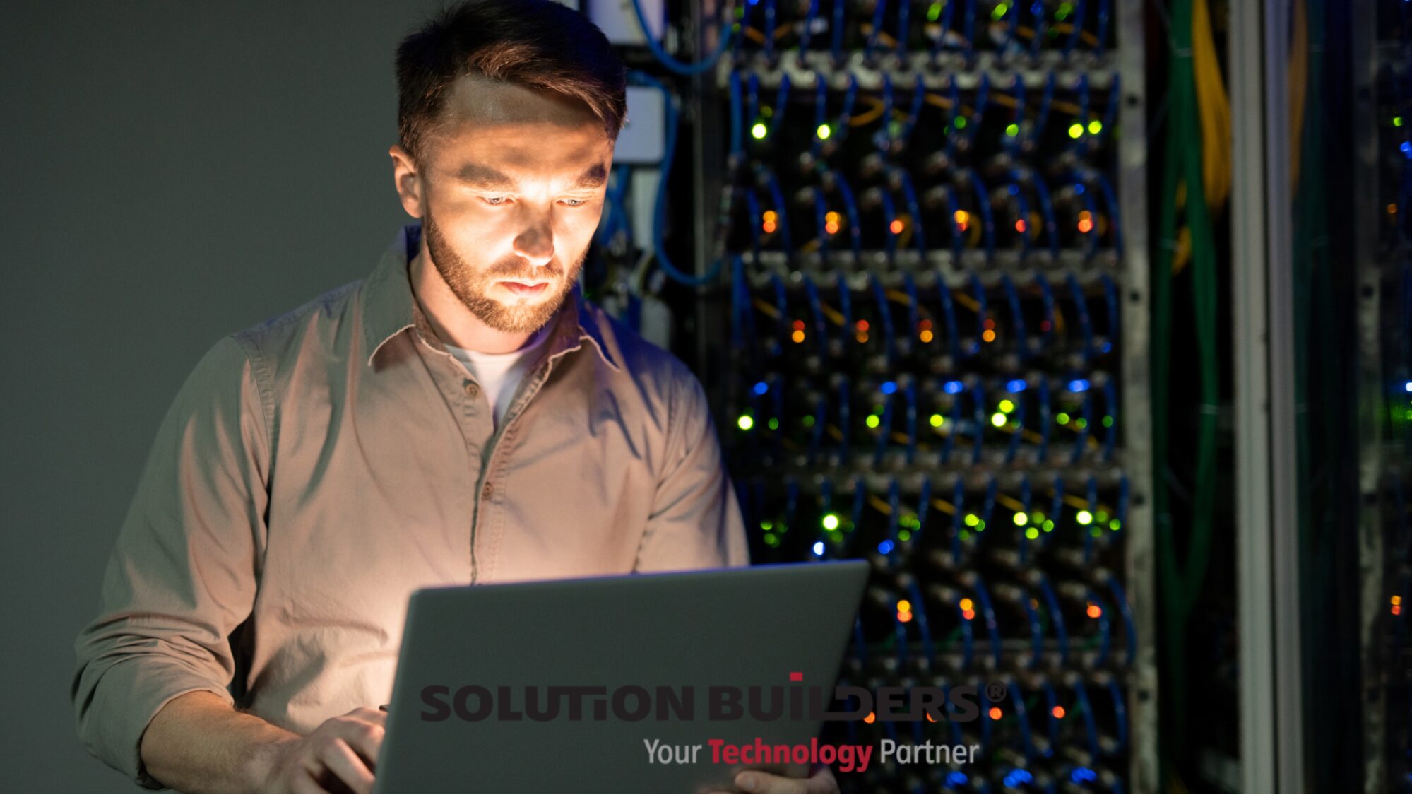 managed-it Solution Builders IT professional working on a laptop in a server room